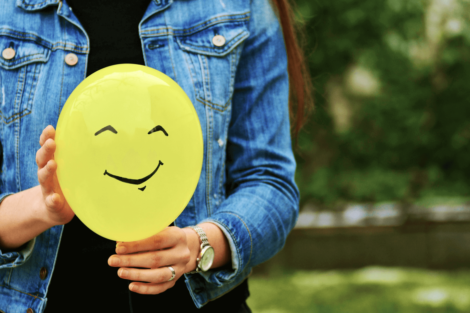 This image shows a person holding a smiley representing the importance of good donor retention strategies for nonprofits