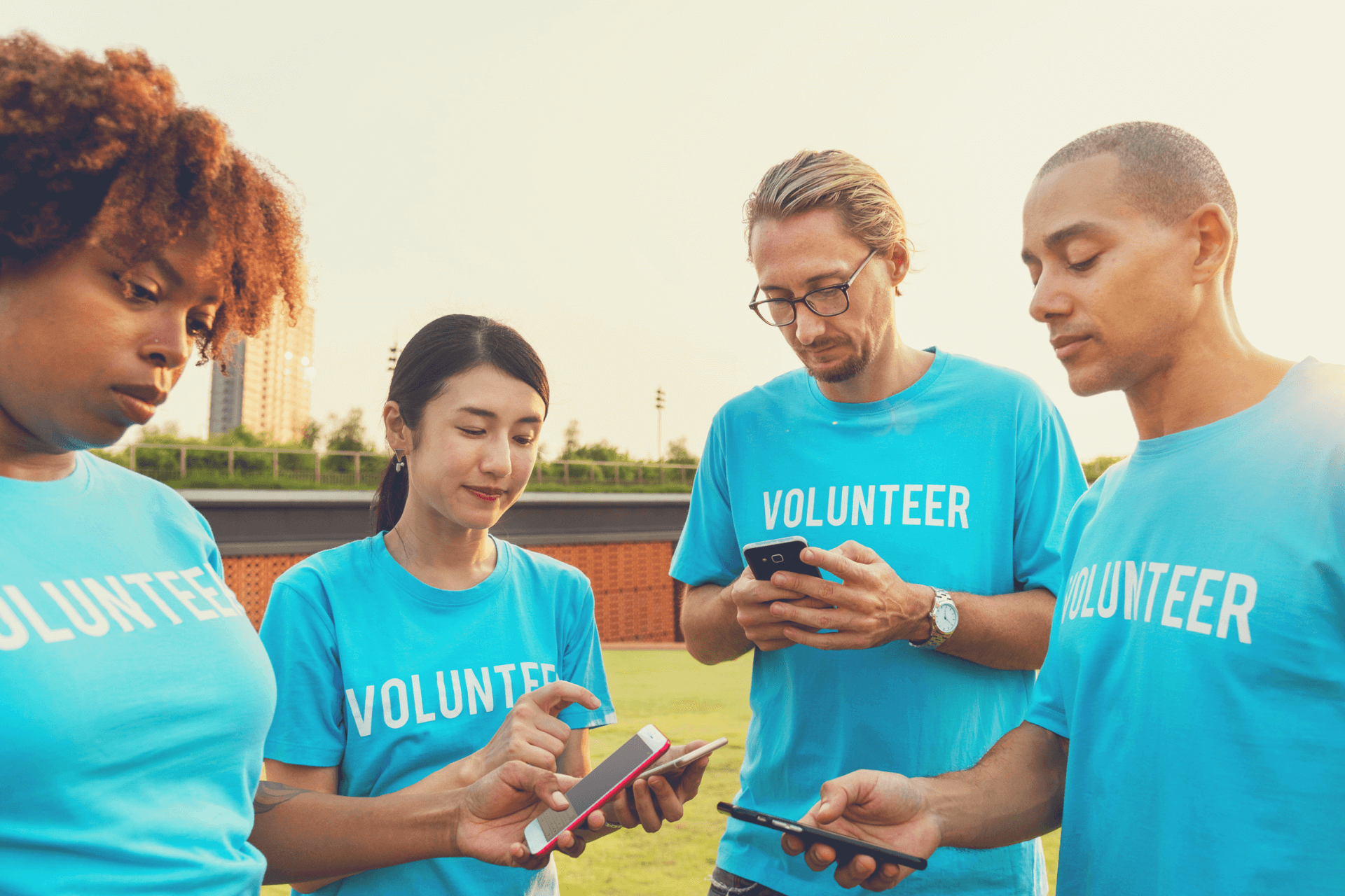 This image portrays four volunteers using social media features to show the good the nonprofit they support is doing 